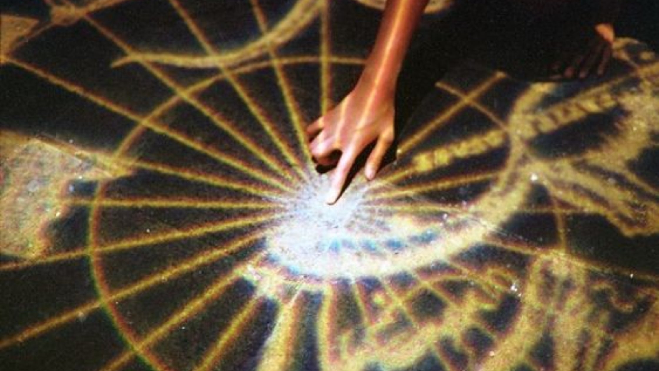 hand reaching to centre of cosmic alchemical design